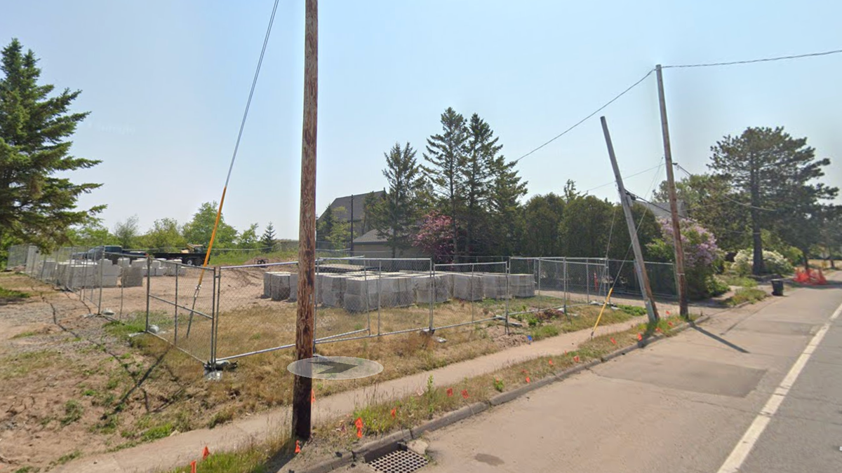 Empty lot with fence around it in Park Point neighborhood.